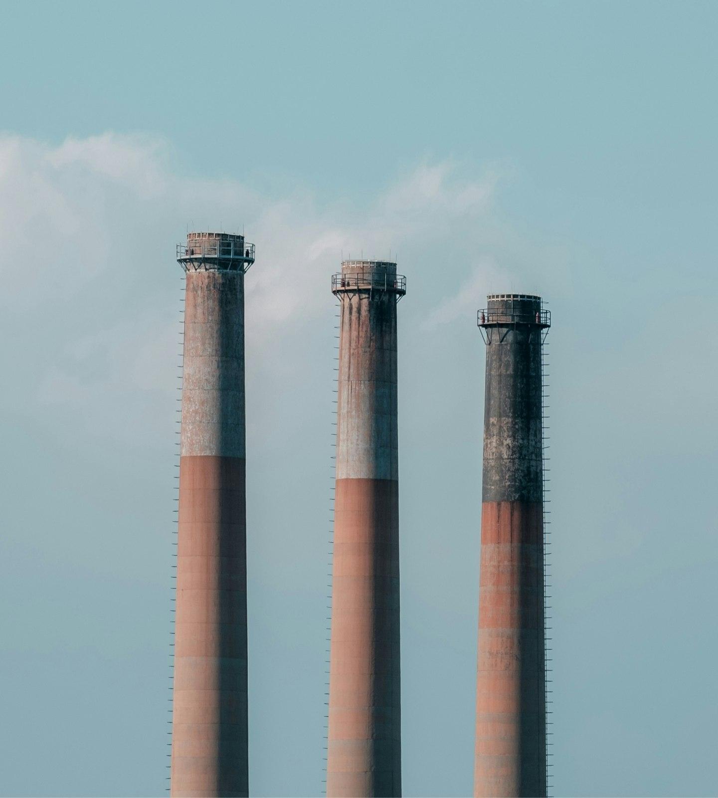Three smoke stacks representing the need for clean energy